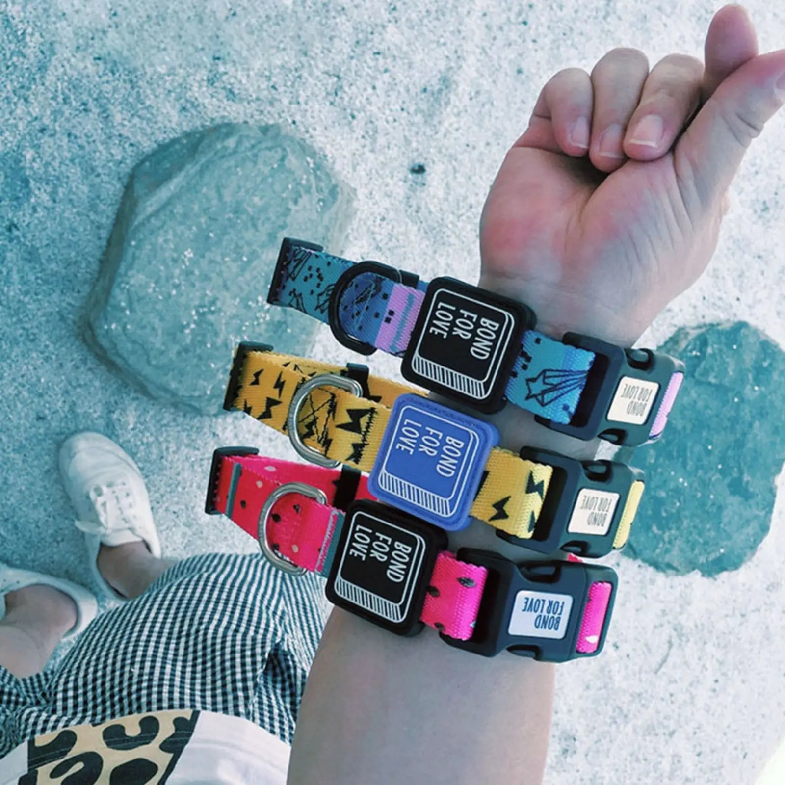 Stack of colorful nylon printed dog collars in yellow, pink, and blue