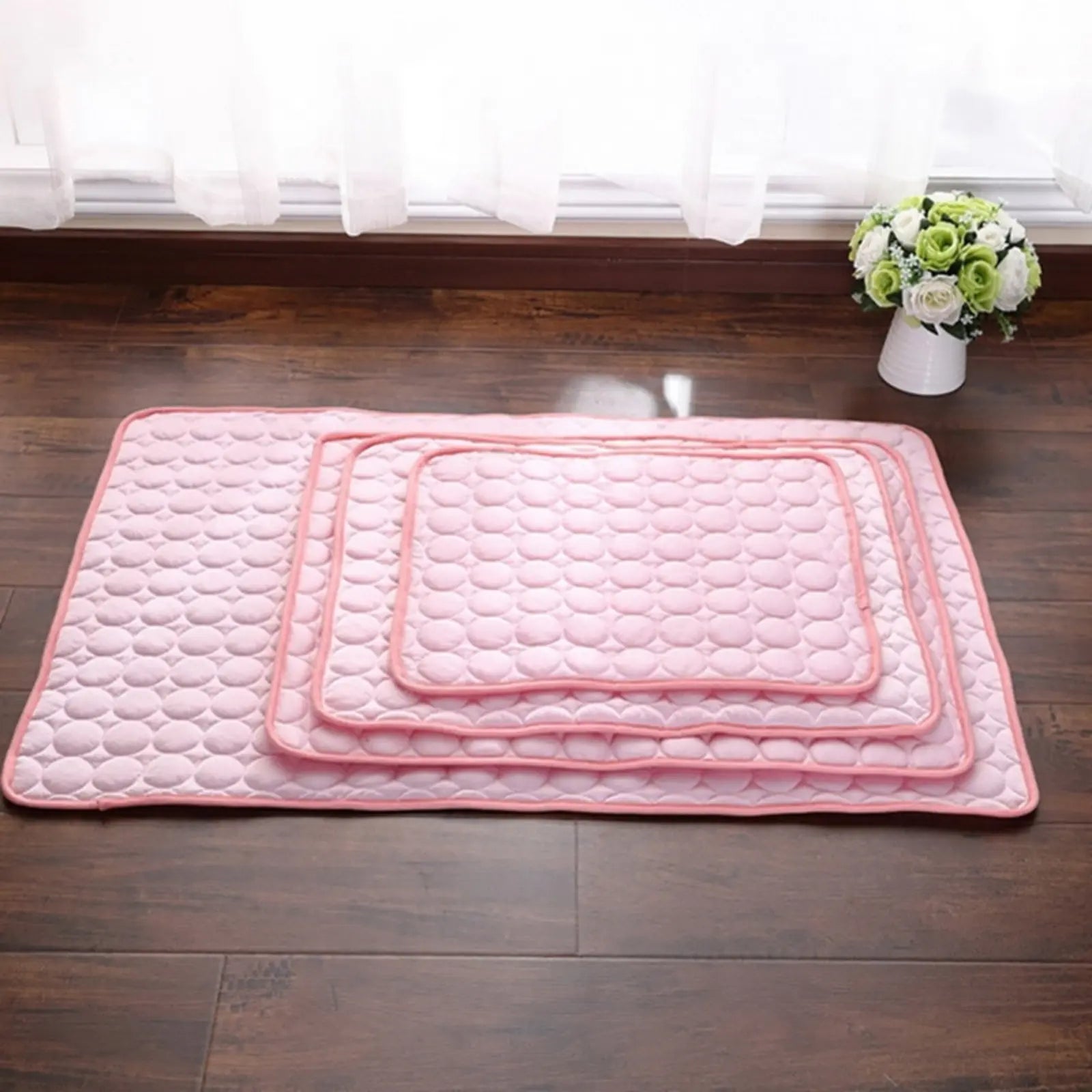 Stacked ChillPaw pink cooling mats in multiple sizes