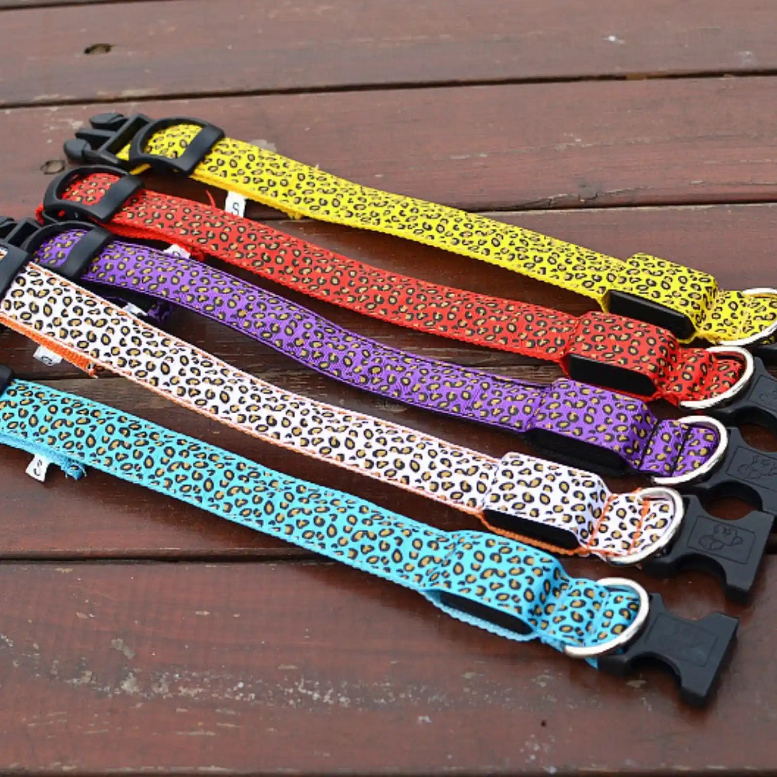 Set of GlowGuard LED dog collars in different colors displayed on wood